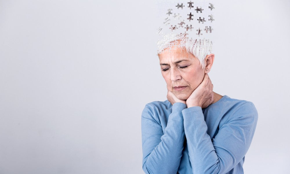 Une femme d'un âge mûre est au centre de l'image. Elle se tient le cou et essaye de réfléchir, mais souffre de perte de mémoire à la ménopause. Ses idées sont en pièces de puzzle.