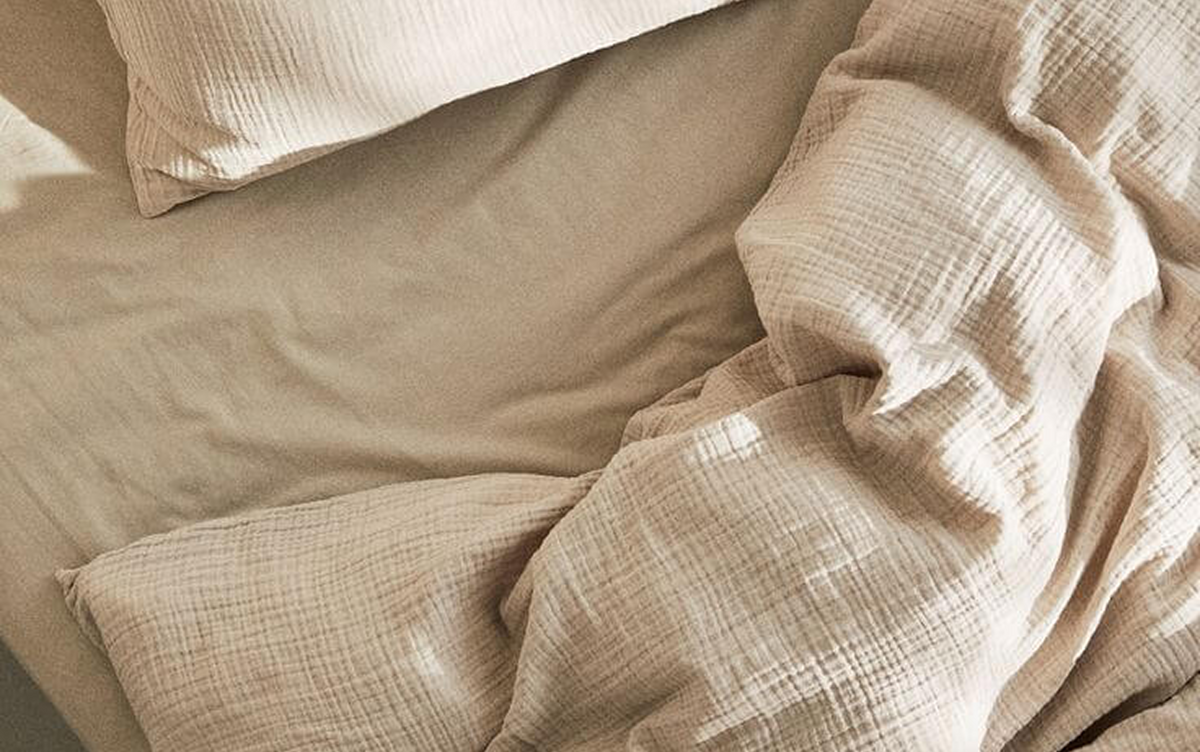 Draps de lit en coton froissés, évoquant une nuit paisible après le retour au calme